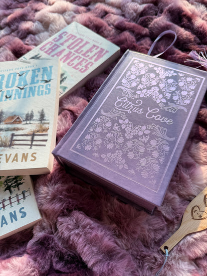 Citrus Cove Omnibus on a blanket surface with three books to the left.